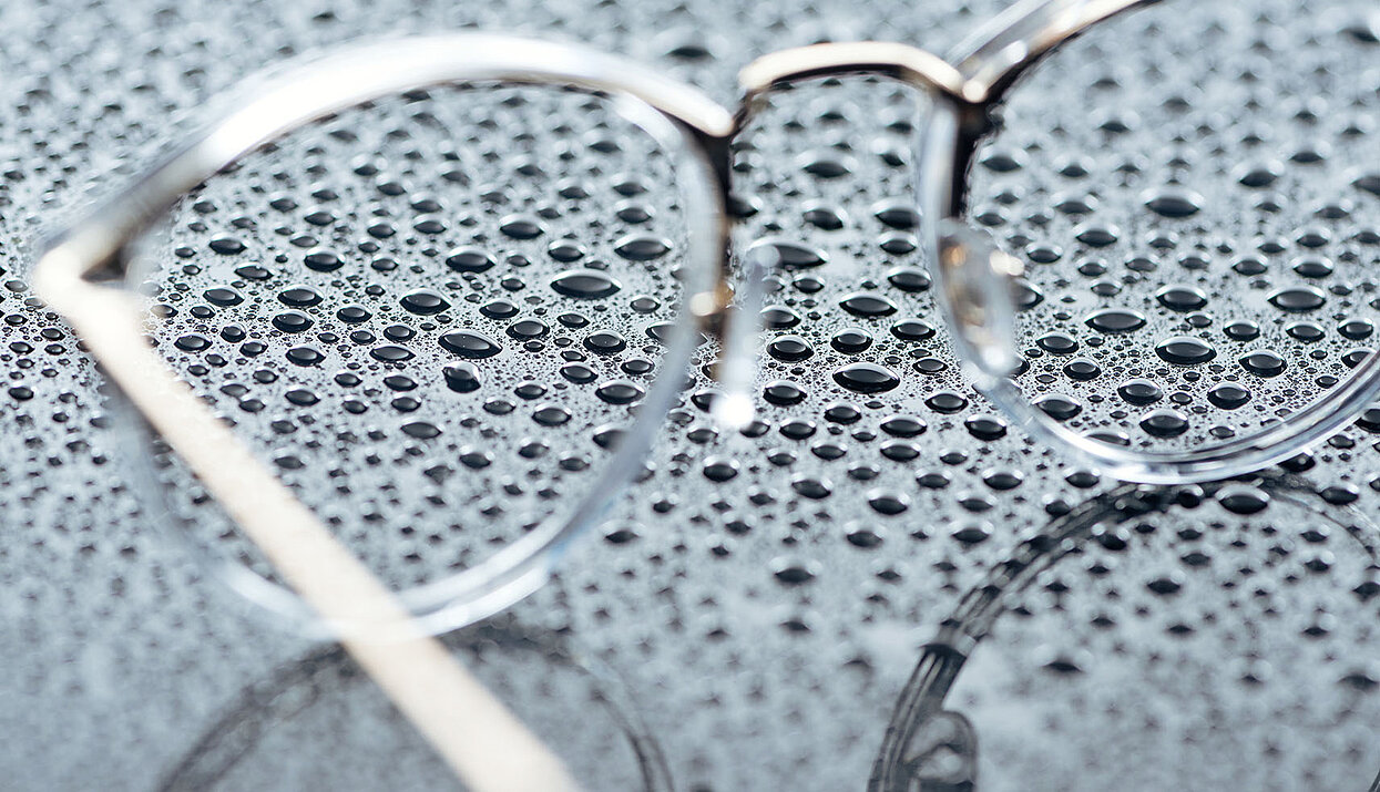 Brillenglas mit Wassertropfen aus der Optikbranche, gereinigt von CAVISONIC